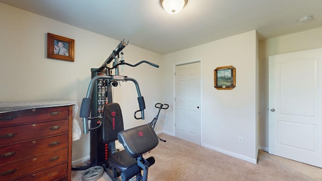 workout room featuring light carpet