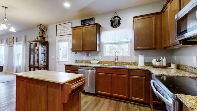 kitchen with stainless steel appliances, a notable chandelier, decorative light fixtures, dark hardwood / wood-style flooring, and sink