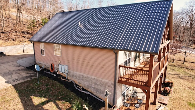 view of home's exterior with a patio area and a wooden deck