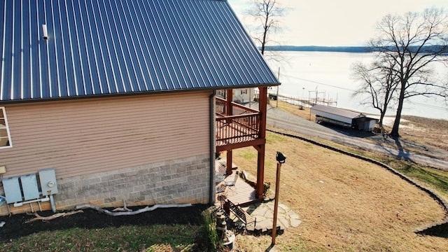 view of property exterior with a deck with water view