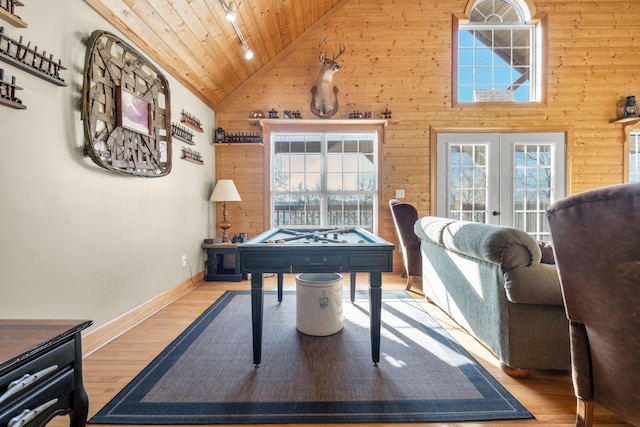 recreation room with french doors, light hardwood / wood-style flooring, wooden ceiling, and wood walls