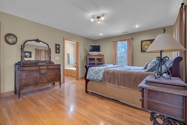 bedroom with light hardwood / wood-style flooring and ensuite bath