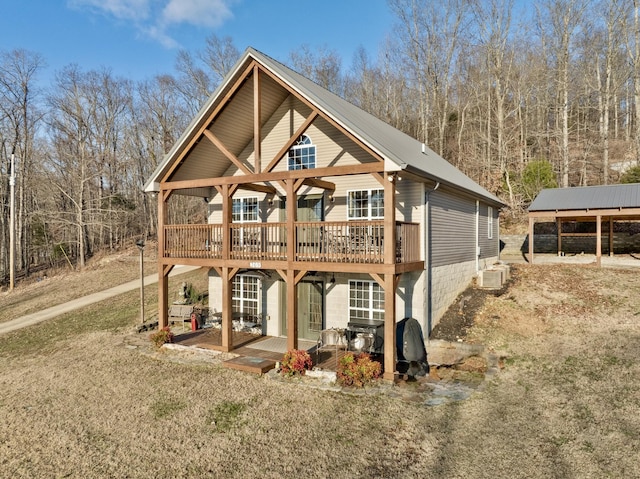 view of front of property featuring a deck, metal roof, and a front yard