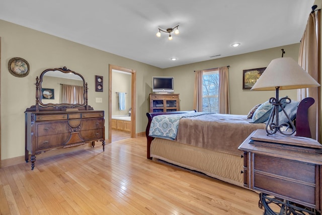 bedroom featuring recessed lighting, ensuite bath, light wood-style flooring, and baseboards