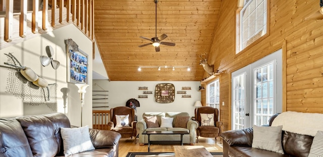 living room featuring french doors, rail lighting, a high ceiling, a ceiling fan, and wood finished floors