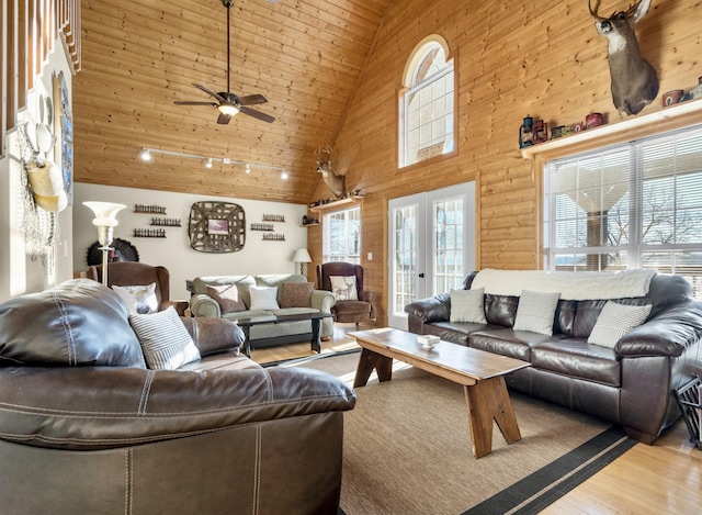 living area featuring high vaulted ceiling, wood walls, wood finished floors, wood ceiling, and french doors