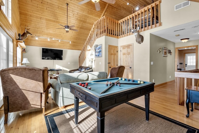 game room with visible vents, a towering ceiling, a ceiling fan, wood finished floors, and wooden ceiling