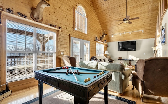 playroom featuring french doors, wood-type flooring, a ceiling fan, wood walls, and high vaulted ceiling