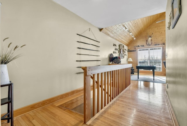 hall featuring high vaulted ceiling, wood-type flooring, and wooden ceiling