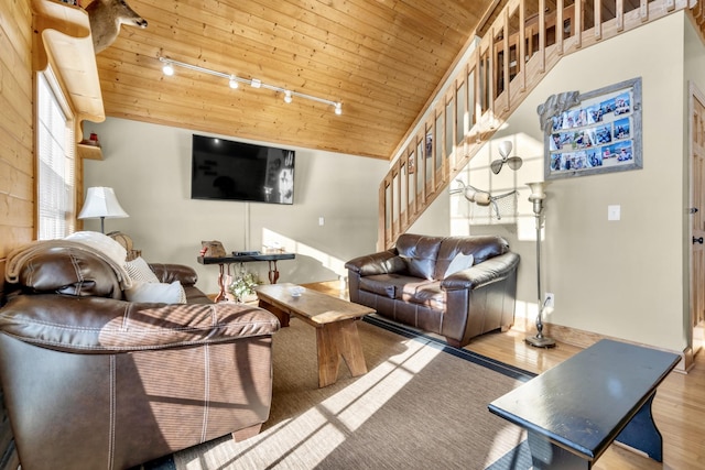 living area with vaulted ceiling, track lighting, wood finished floors, wooden ceiling, and stairs