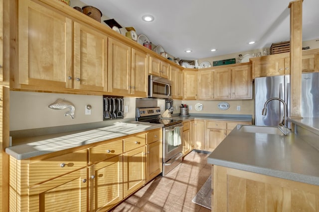 kitchen with appliances with stainless steel finishes, recessed lighting, light brown cabinets, and a sink