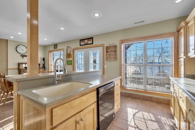 kitchen featuring black dishwasher, visible vents, a sink, and light brown cabinetry