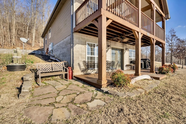 exterior space featuring concrete block siding, a patio area, and french doors