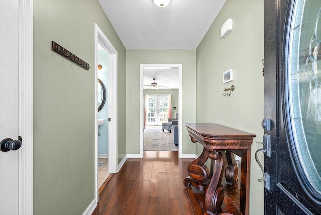 corridor featuring wood-type flooring and a textured ceiling