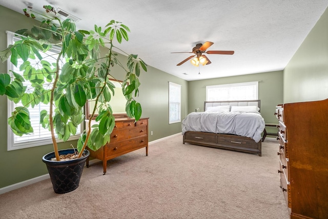 carpeted bedroom featuring ceiling fan and a textured ceiling