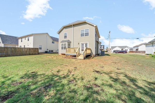 rear view of house featuring a wooden deck and a yard