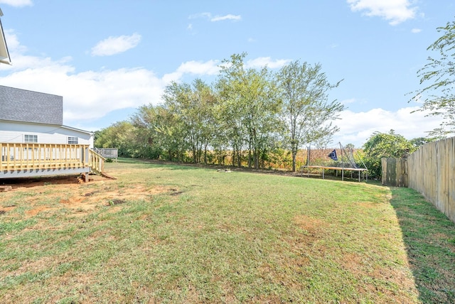 view of yard featuring a wooden deck and a trampoline