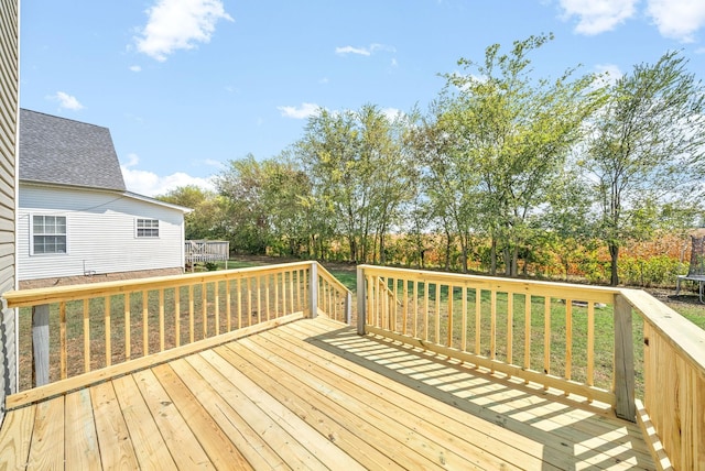 wooden deck with a lawn and a trampoline