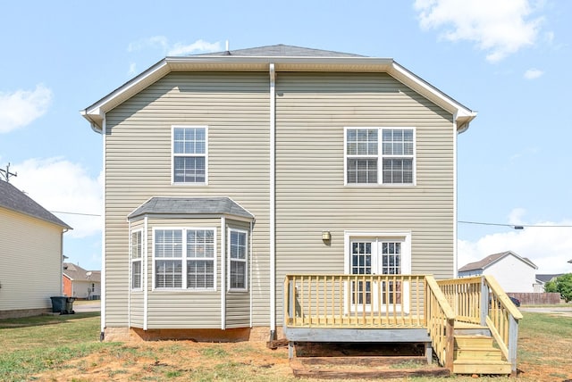 back of property featuring a lawn and a wooden deck