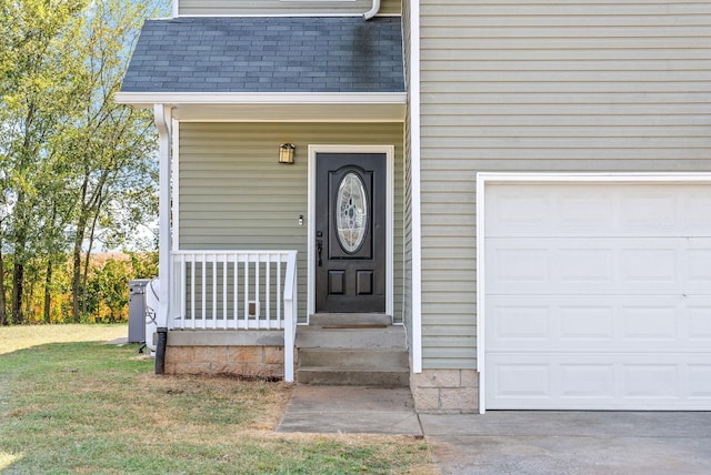 entrance to property featuring a garage and a yard