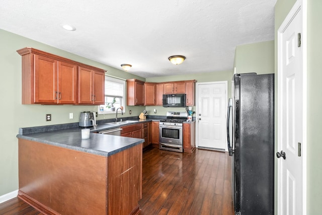 kitchen with dark hardwood / wood-style flooring, sink, black appliances, and a textured ceiling