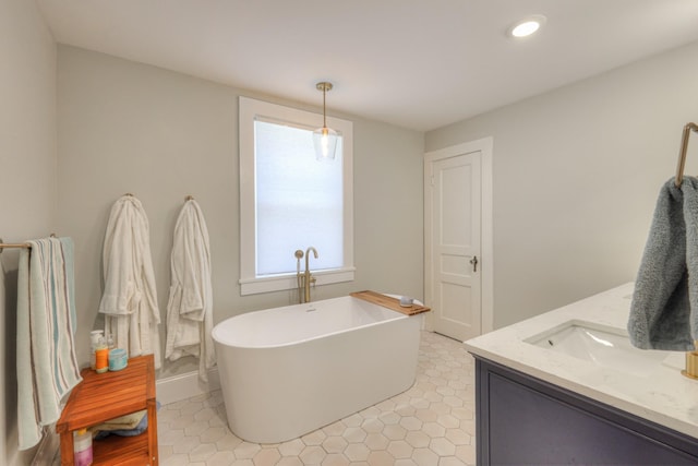 bathroom with a tub, tile patterned flooring, and vanity