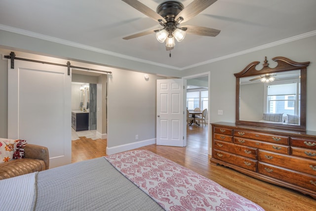 bedroom featuring connected bathroom, ceiling fan, a barn door, light hardwood / wood-style flooring, and ornamental molding