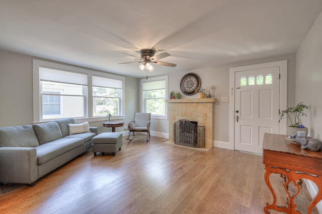 living room with ceiling fan, light hardwood / wood-style floors, and a fireplace