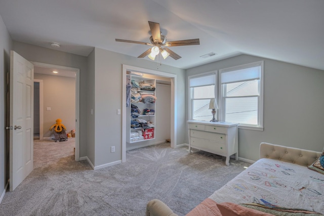 bedroom featuring ceiling fan, vaulted ceiling, light colored carpet, and a closet