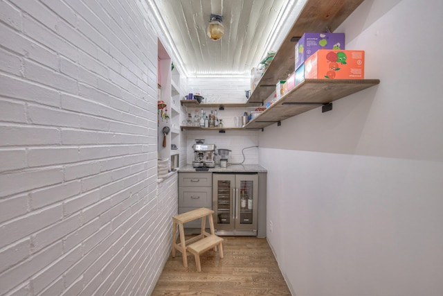 bar featuring decorative backsplash, beverage cooler, and light hardwood / wood-style floors