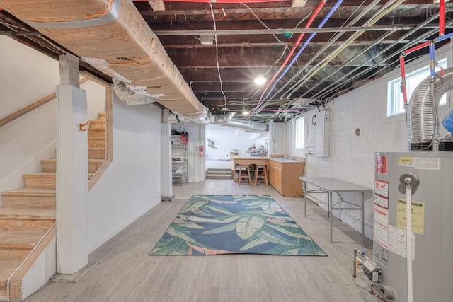 basement featuring wood-type flooring and gas water heater