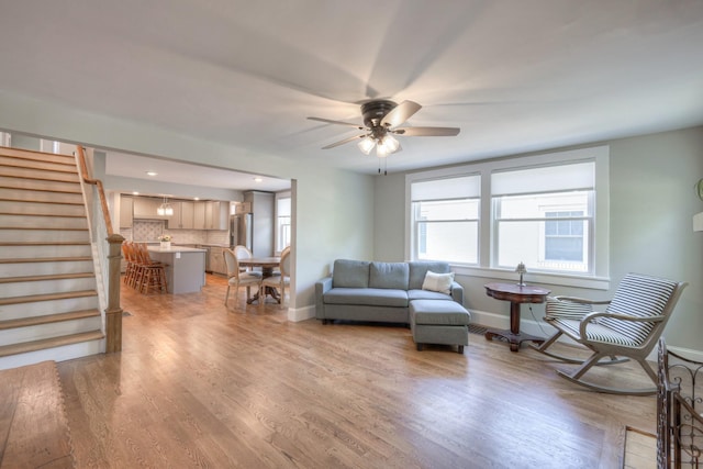 living room with ceiling fan and light hardwood / wood-style flooring