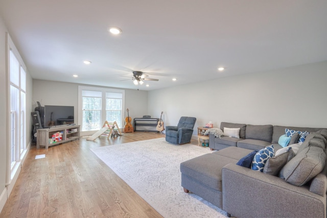 living room featuring ceiling fan and light hardwood / wood-style floors