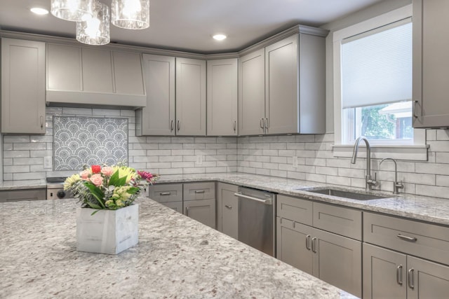 kitchen with sink, stainless steel dishwasher, decorative backsplash, gray cabinets, and decorative light fixtures