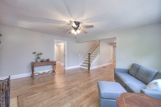 living room featuring ceiling fan and light hardwood / wood-style flooring