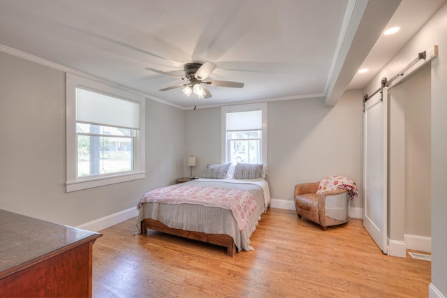 bedroom featuring ceiling fan, a barn door, and ornamental molding