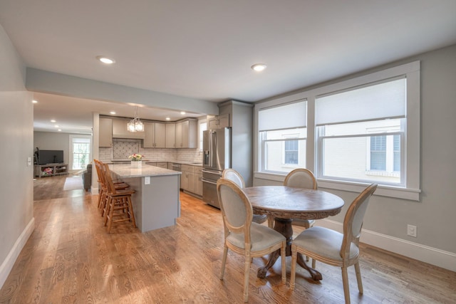 dining space featuring plenty of natural light, an inviting chandelier, and light hardwood / wood-style flooring