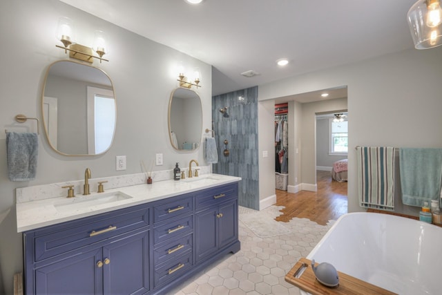 bathroom featuring vanity, a tub to relax in, tile patterned floors, and ceiling fan