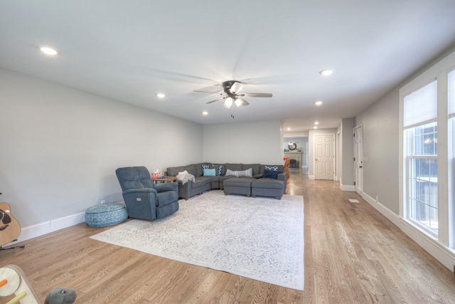 living room with ceiling fan and light hardwood / wood-style flooring