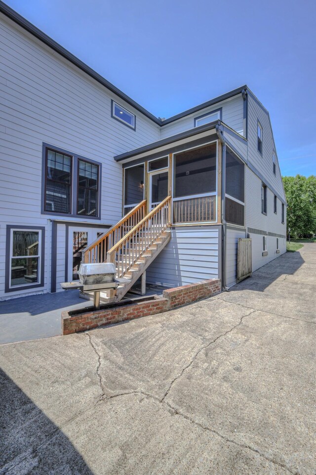 rear view of house with a sunroom and a patio