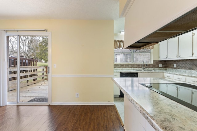 kitchen with sink, tasteful backsplash, dark hardwood / wood-style flooring, stainless steel dishwasher, and white cabinets