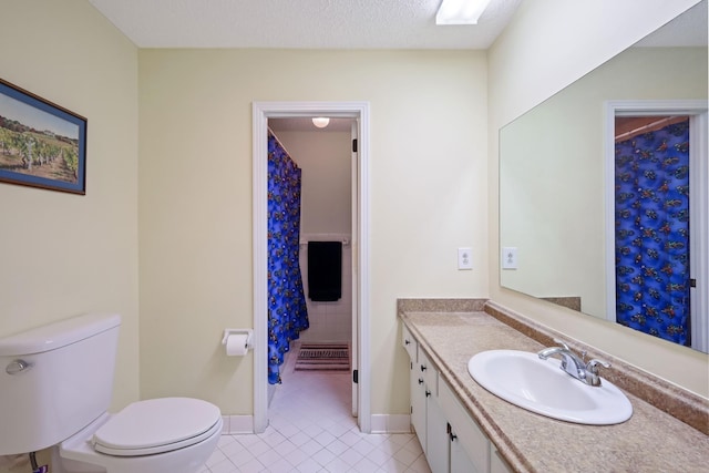 bathroom featuring tile patterned flooring, vanity, toilet, and a textured ceiling