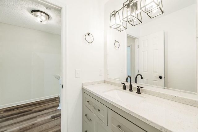 bathroom featuring vanity, wood-type flooring, and a textured ceiling