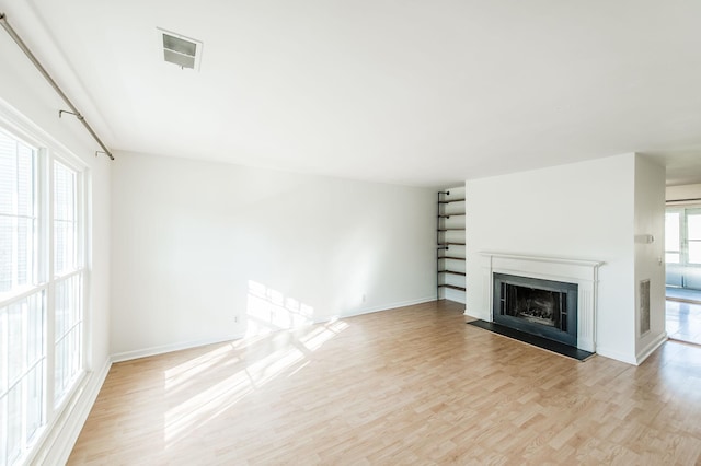 unfurnished living room featuring a healthy amount of sunlight and light hardwood / wood-style floors