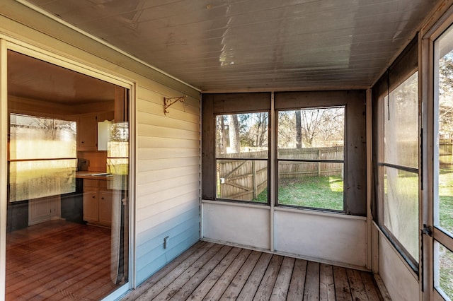 unfurnished sunroom with a healthy amount of sunlight and lofted ceiling