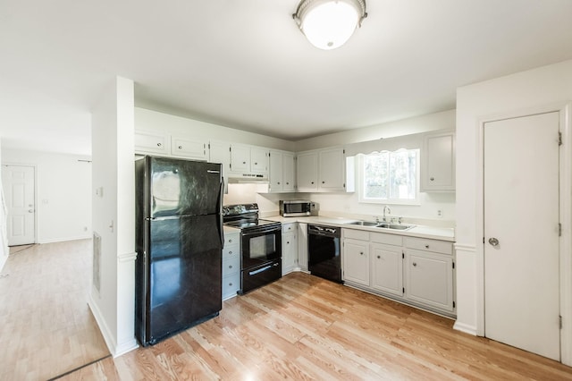 kitchen with sink, light hardwood / wood-style floors, and black appliances