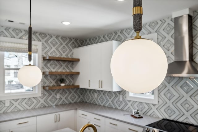 kitchen with stove, backsplash, white cabinetry, and plenty of natural light