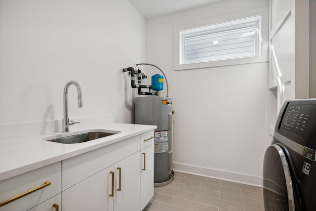 washroom with cabinets, sink, light tile patterned floors, water heater, and washer / dryer