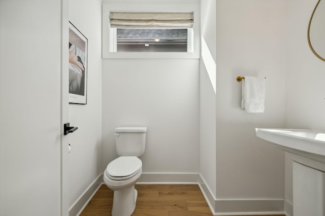 bathroom featuring hardwood / wood-style flooring and toilet