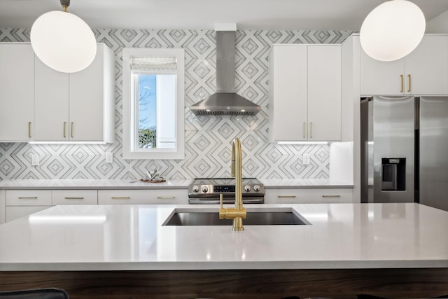 kitchen with decorative backsplash, wall chimney exhaust hood, a kitchen island with sink, pendant lighting, and white cabinets